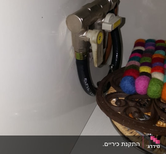 שסתום גז עם צינור שחור מחובר לקיר